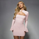 Woman wearing a pink dress with long sleeves on a gray background